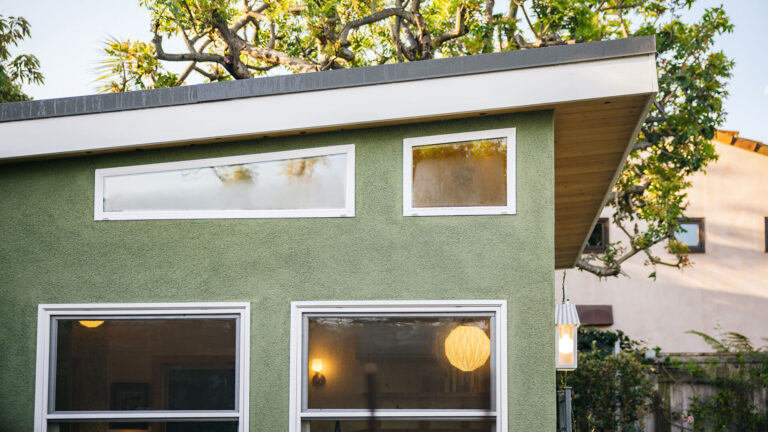 Green shed exterior with horizontal windows and flat roof