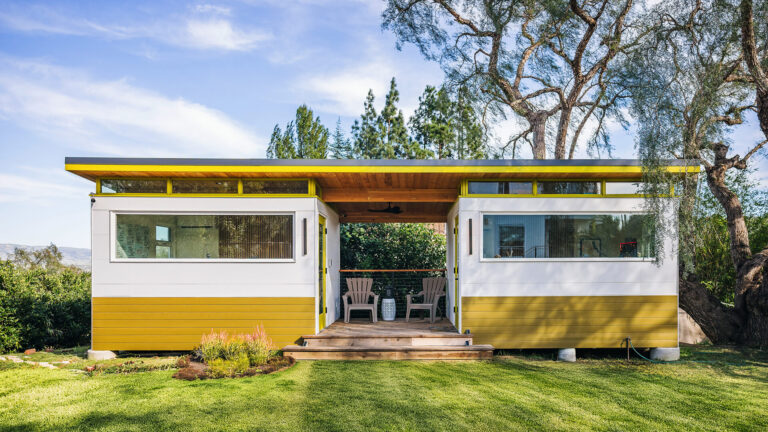 Modern prefab shed with covered patio and lawn